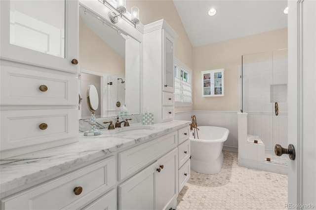 10 Oakmont Ln, Littleton, CO 80127 - full bathroom featuring a stall shower, lofted ceiling, vanity, a freestanding tub, and a wainscoted wall