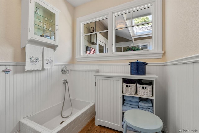10 Oakmont Ln, Littleton, CO 80127 - bathroom featuring a wainscoted wall, a bathtub, and a skylight