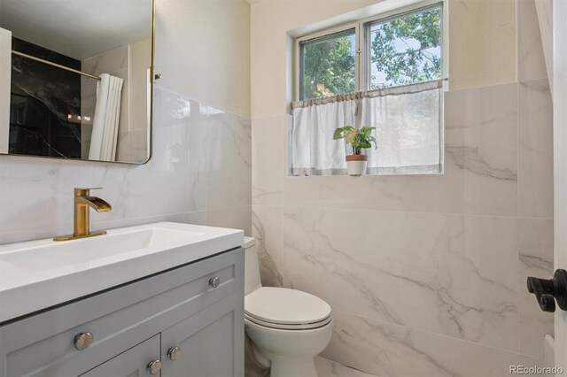 1497 S Garfield St, Denver, CO 80210 - bathroom featuring tile walls, vanity, and a marble finish shower