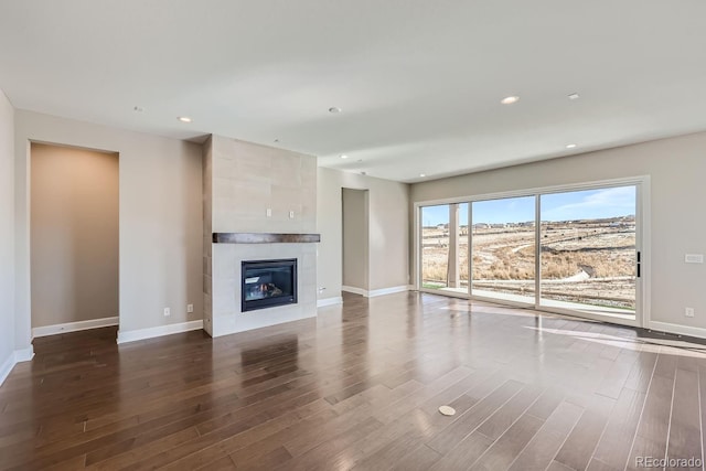 unfurnished living room with hardwood / wood-style floors and a tile fireplace