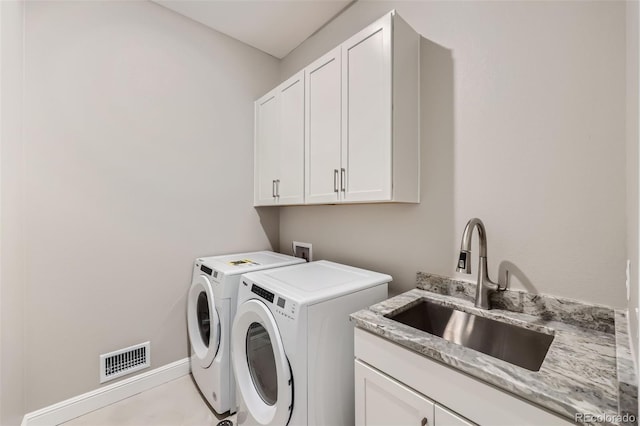 laundry room with cabinets, separate washer and dryer, and sink