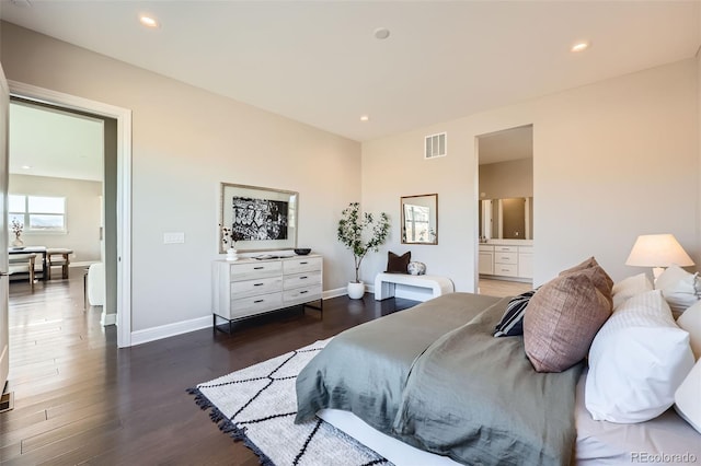 bedroom with ensuite bath and dark wood-type flooring