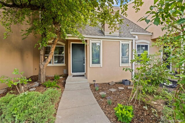 13025 E Bethany Pl, Aurora, CO 80014 - entrance to property featuring roof with shingles and stucco siding