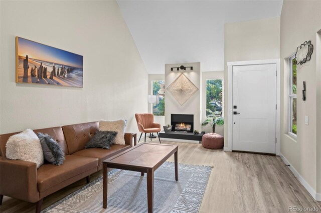 13025 E Bethany Pl, Aurora, CO 80014 - living room featuring light wood-type flooring, plenty of natural light, and a warm lit fireplace