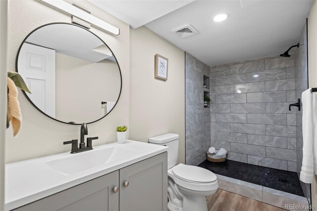 13025 E Bethany Pl, Aurora, CO 80014 - bathroom featuring wood finished floors, vanity, and a tile shower