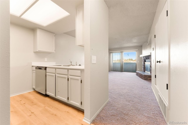 corridor featuring a textured ceiling, light hardwood / wood-style floors, and sink