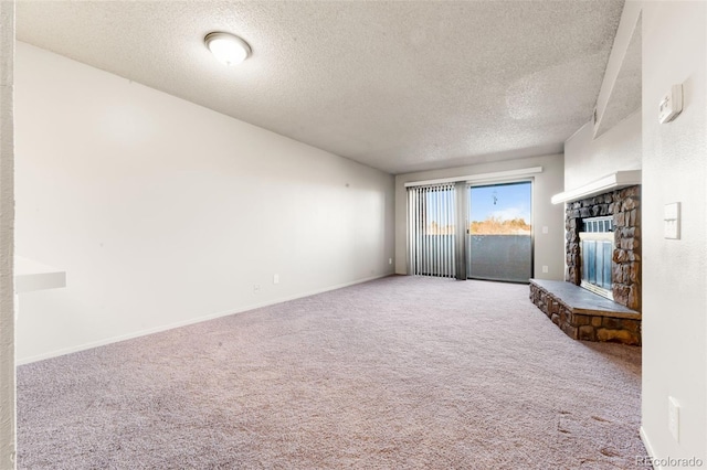 unfurnished living room featuring a textured ceiling, carpet floors, and a fireplace