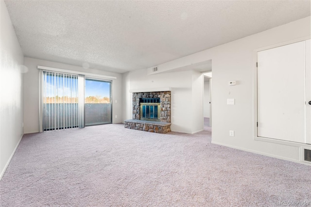 unfurnished living room with a fireplace, carpet, and a textured ceiling