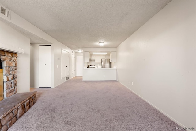 unfurnished living room with carpet and a textured ceiling