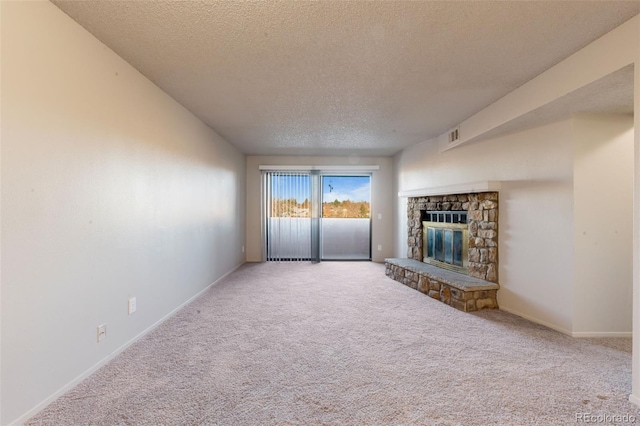 unfurnished living room with carpet flooring, a fireplace, and a textured ceiling