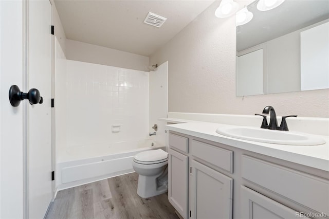 full bathroom with bathing tub / shower combination, toilet, vanity, and hardwood / wood-style flooring