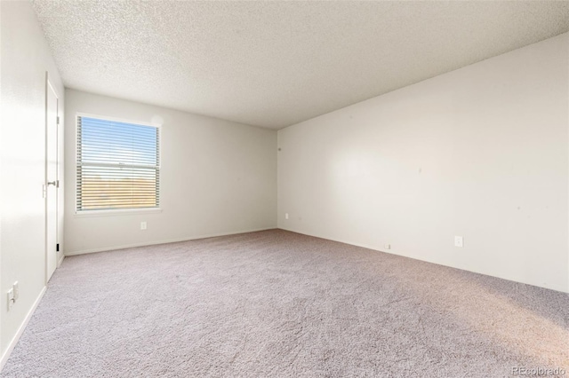 spare room with light colored carpet and a textured ceiling