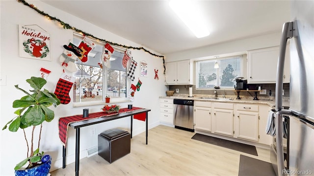 kitchen featuring white cabinetry, light wood-type flooring, and appliances with stainless steel finishes