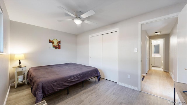 bedroom featuring ceiling fan, light hardwood / wood-style floors, and a closet