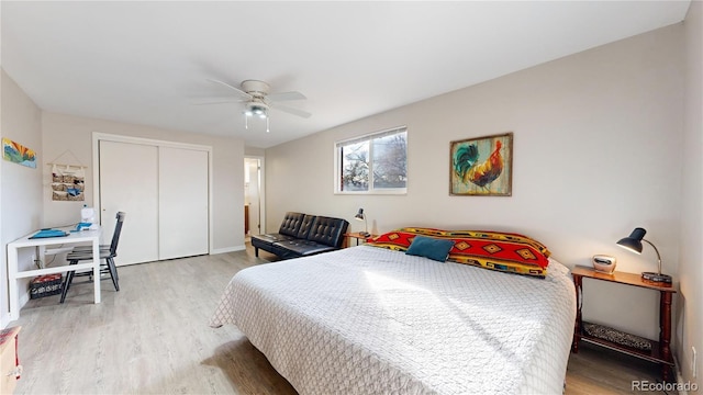 bedroom with ceiling fan, light hardwood / wood-style floors, and a closet