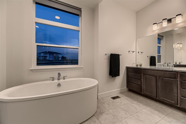 8868 Geyser Peak Way, Parker, CO 80138 - bathroom featuring double vanity, a freestanding tub, baseboards, and tile patterned floors