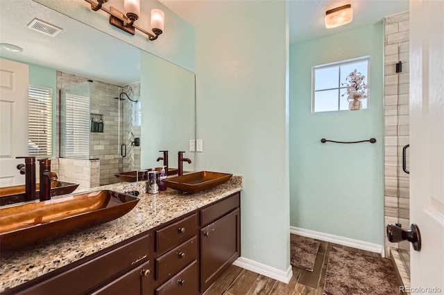 bathroom featuring vanity, hardwood / wood-style floors, and a shower with door