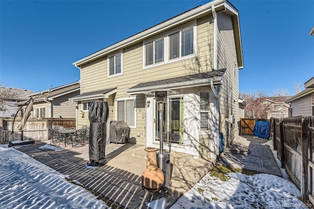 snow covered house featuring a patio