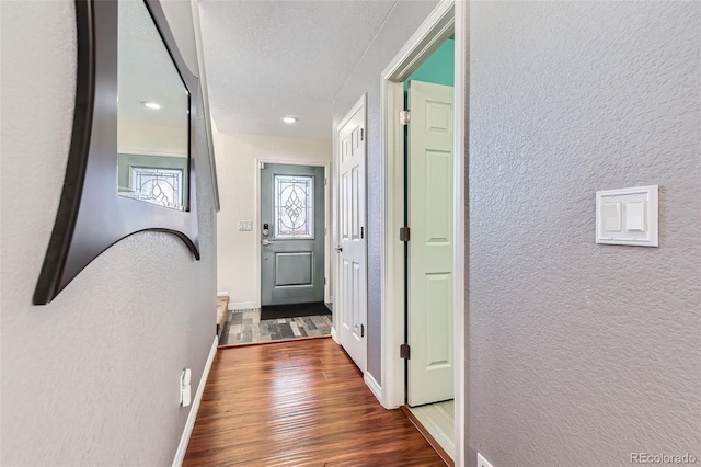 corridor with dark wood-type flooring and a textured ceiling