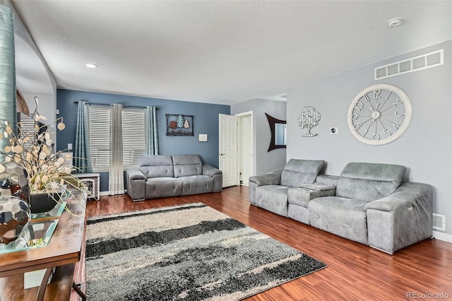 living room featuring dark hardwood / wood-style floors and a textured ceiling