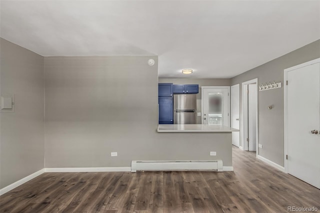 unfurnished living room with dark hardwood / wood-style floors and a baseboard heating unit