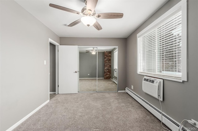 unfurnished bedroom with an AC wall unit, ceiling fan, a baseboard radiator, light colored carpet, and a closet