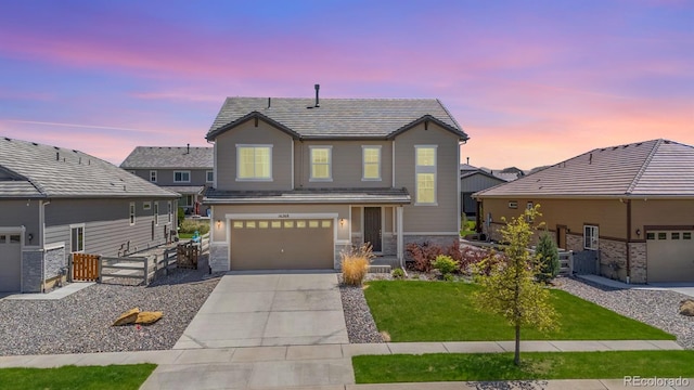 16268 Mount Silverheels Way, Broomfield, CO 80023 - view of front of home featuring concrete driveway, stone siding, a garage, and a tiled roof
