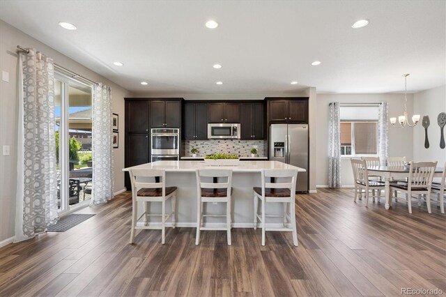 16268 Mount Silverheels Way, Broomfield, CO 80023 - kitchen featuring stainless steel appliances, dark wood-style flooring, a kitchen island, decorative backsplash, and recessed lighting