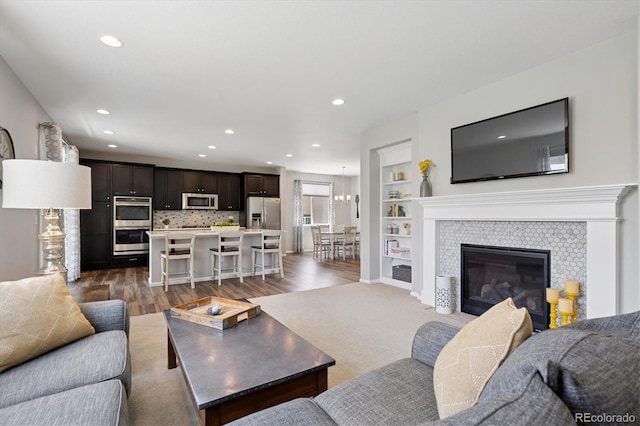 16268 Mount Silverheels Way, Broomfield, CO 80023 - living area with recessed lighting, wood finished floors, built in shelves, and a tiled fireplace