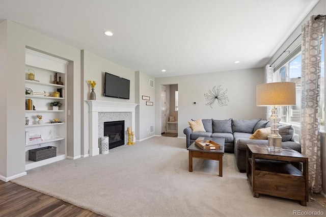 16268 Mount Silverheels Way, Broomfield, CO 80023 - living room with a fireplace with flush hearth, wood finished floors, built in shelves, baseboards, and recessed lighting