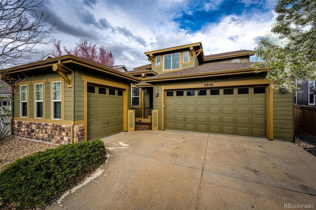 prairie-style house with a garage, stone siding, and concrete driveway