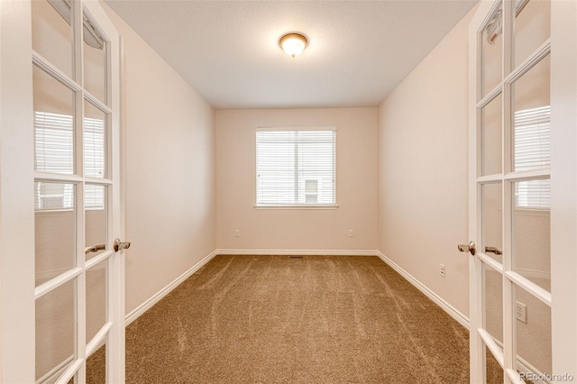 unfurnished room with carpet floors, french doors, and baseboards