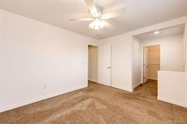 carpeted empty room featuring baseboards and ceiling fan