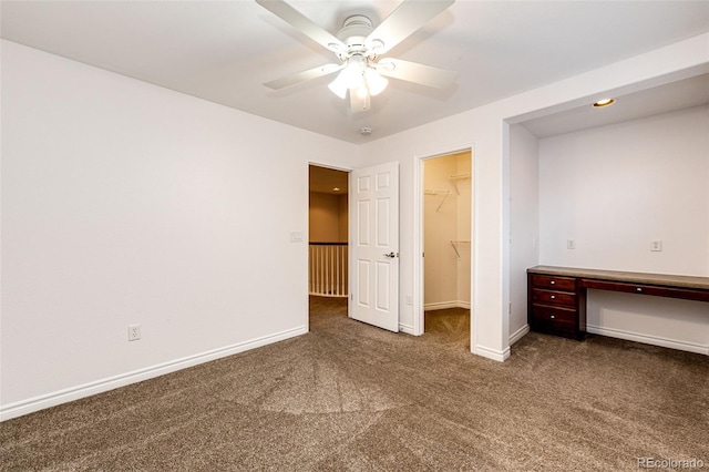 unfurnished bedroom with a spacious closet, baseboards, a closet, and carpet
