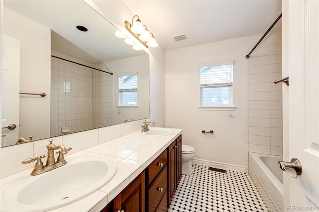 full bathroom with toilet, a sink, visible vents, and baseboards
