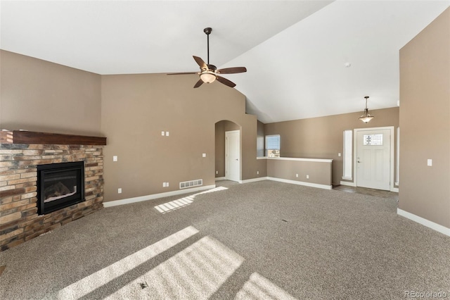 unfurnished living room featuring ceiling fan, a stone fireplace, carpet flooring, and high vaulted ceiling