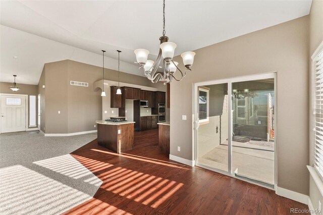 kitchen featuring dark wood-type flooring, pendant lighting, lofted ceiling, a center island, and dark brown cabinetry