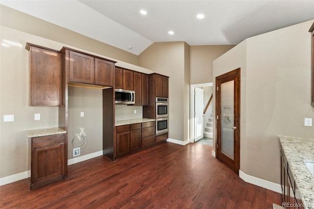 kitchen with light stone countertops, stainless steel appliances, lofted ceiling, and dark hardwood / wood-style flooring