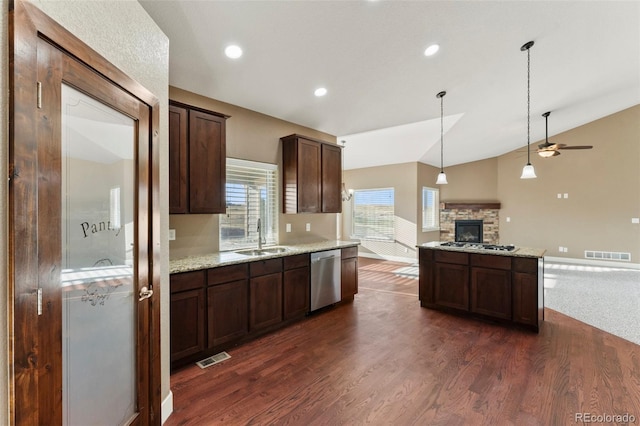 kitchen with sink, lofted ceiling, stainless steel appliances, dark hardwood / wood-style flooring, and light stone countertops