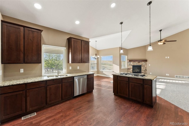 kitchen with vaulted ceiling, light stone counters, dark hardwood / wood-style flooring, stainless steel appliances, and sink