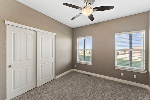 unfurnished bedroom featuring carpet, ceiling fan, and a closet