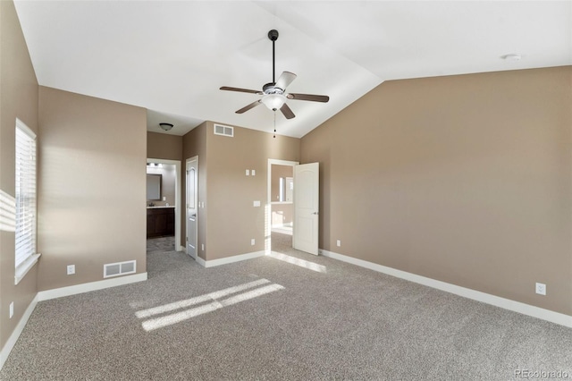 unfurnished bedroom with connected bathroom, vaulted ceiling, ceiling fan, and light colored carpet