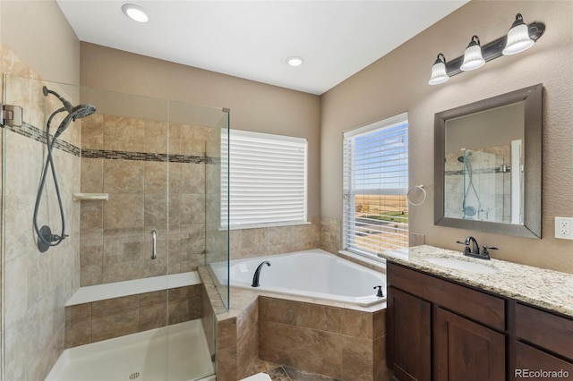 bathroom featuring vanity and shower with separate bathtub