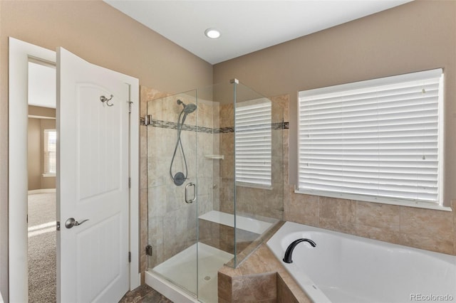 bathroom with shower with separate bathtub and a wealth of natural light