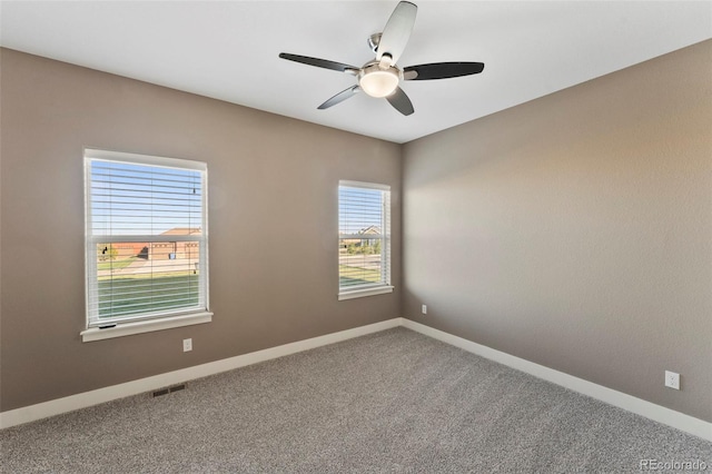 carpeted empty room featuring ceiling fan and a healthy amount of sunlight