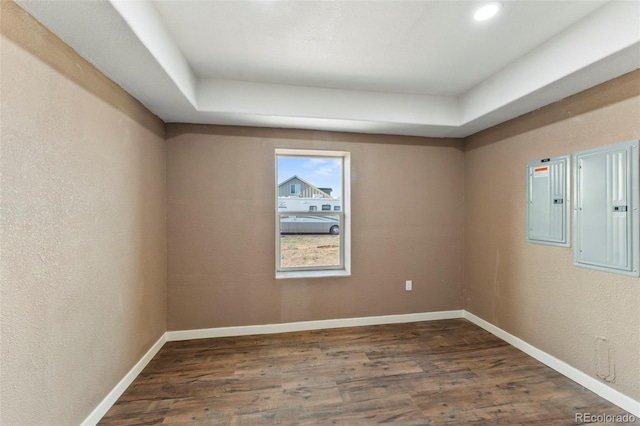 empty room featuring electric panel and dark wood-type flooring