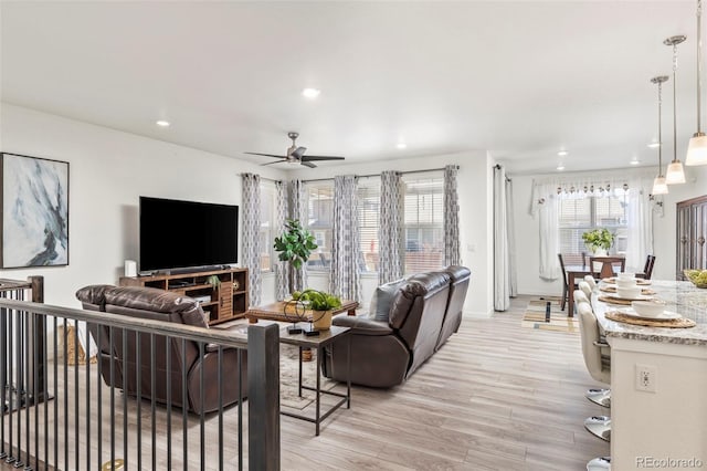 living room with light wood-style floors, baseboards, ceiling fan, and recessed lighting