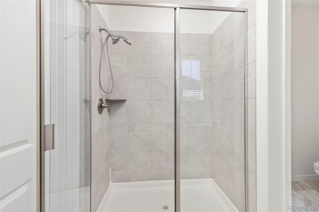 bathroom featuring toilet and a stall shower