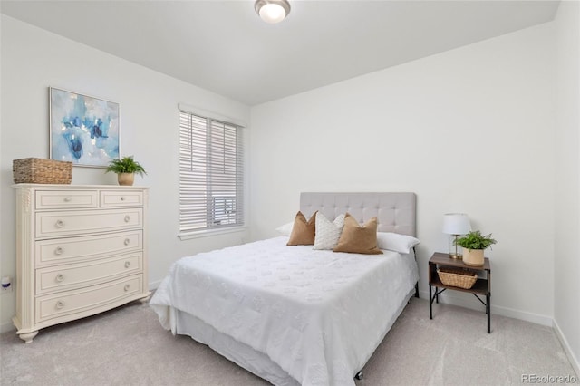 bedroom with baseboards and light carpet