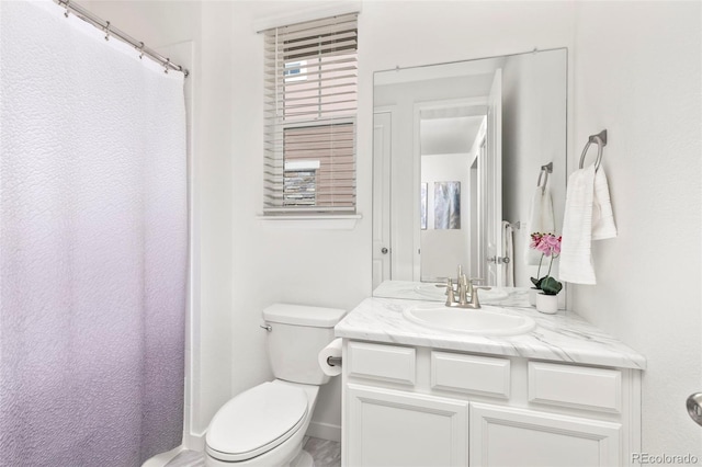 bathroom with toilet, baseboards, and vanity